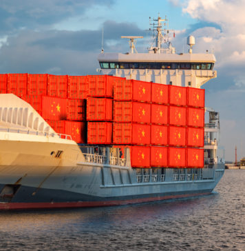 container ship at sea carrying containers with the flag of China