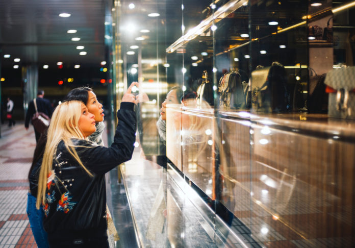 Blonde woman and asian woman go shopping.