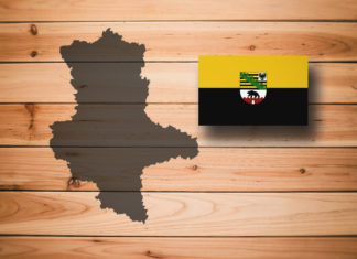 Map and flag of Saxony-Anhalt (Sachsen-Anhalt), German federal state, on wooden background, 3D illustration.