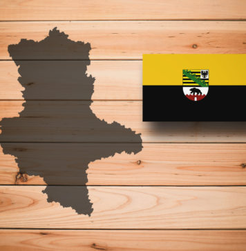 Map and flag of Saxony-Anhalt (Sachsen-Anhalt), German federal state, on wooden background, 3D illustration.