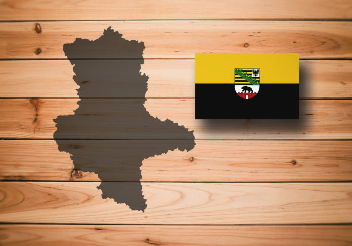 Map and flag of Saxony-Anhalt (Sachsen-Anhalt), German federal state, on wooden background, 3D illustration.